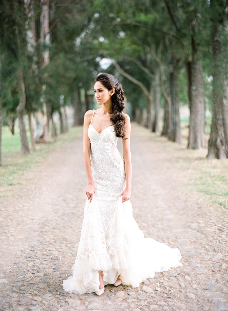 Bride in wedding dress posing in front of trees