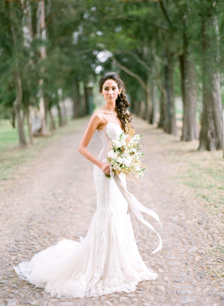 Portrait of woman holding bouquet of flowers in a wedding gown