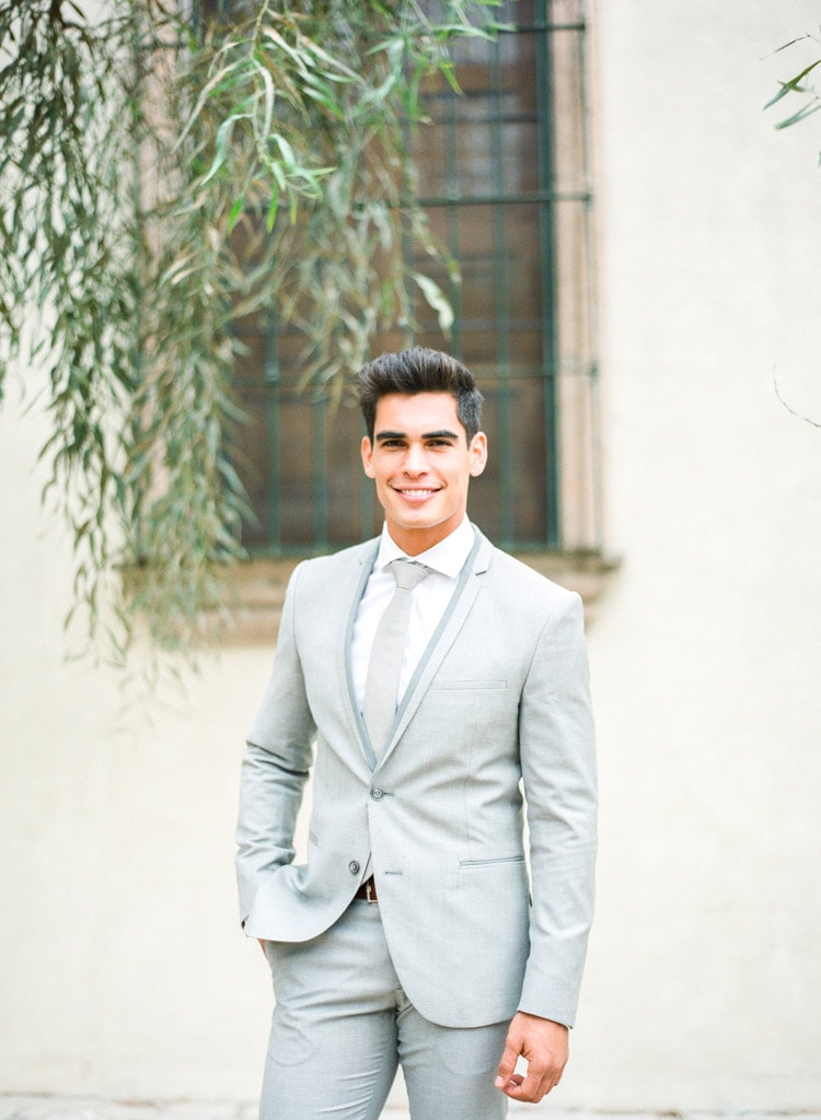 Groom posing for portrait wearing a light gray suit