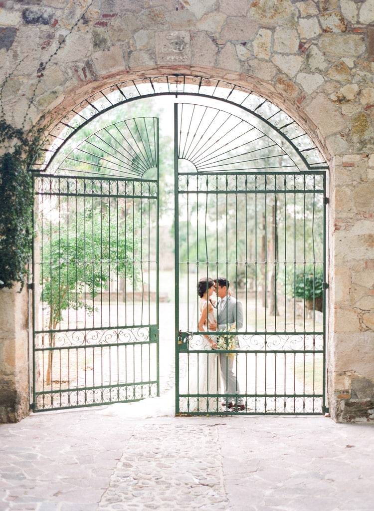 Couple embracing looking closely at each other outside the green gate