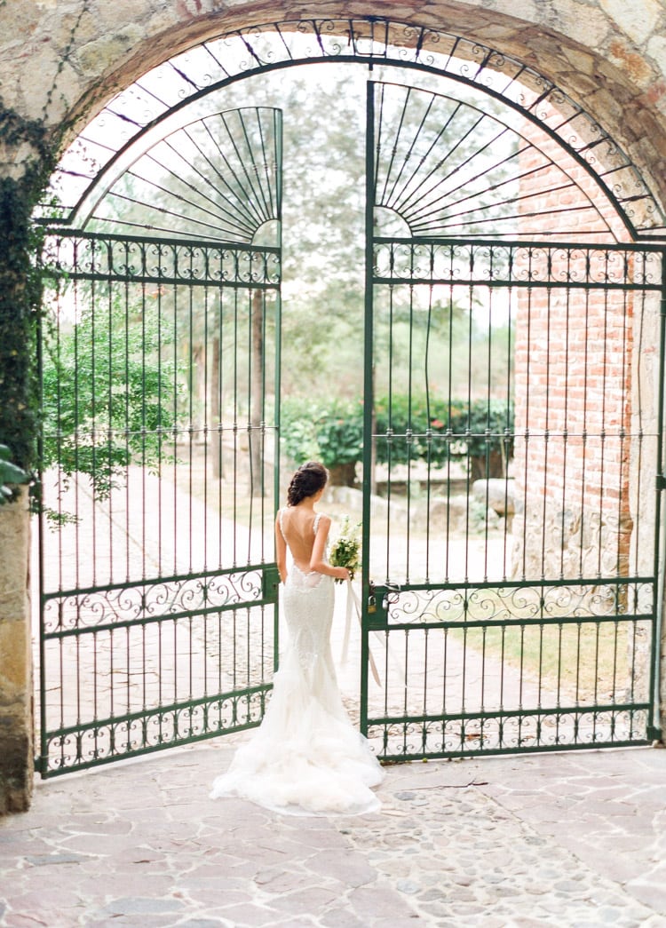 Bride walking through large iron gate