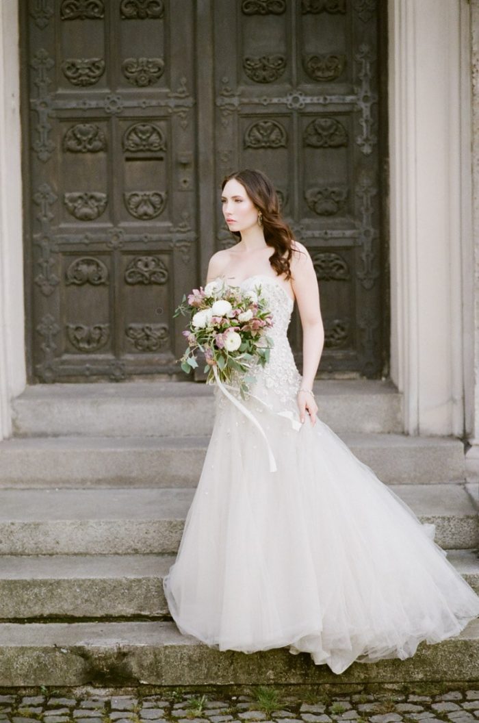 Bride standing on stone steps in Munich Germany