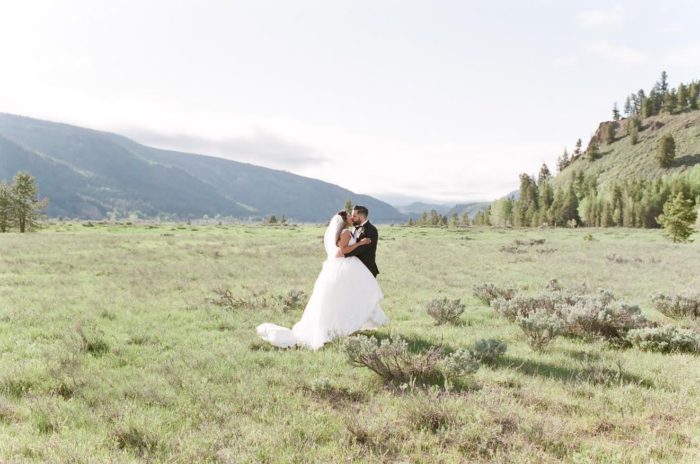 Bride and groom in mountain field at a Camp Hale wedding