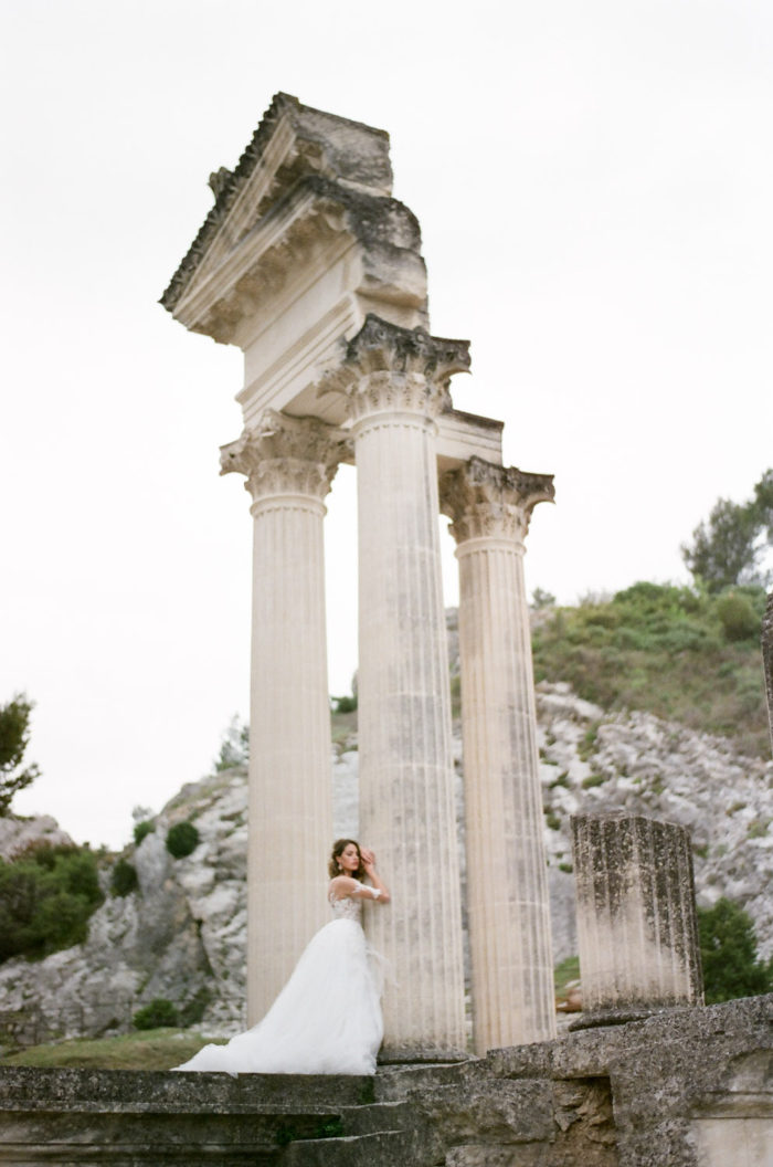 Bride standing in front of architectural ruins in Domaine de Manville