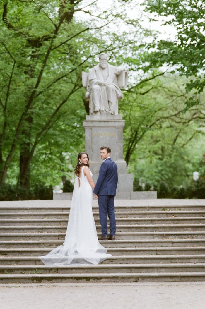 Couple standing on steps in front of statue