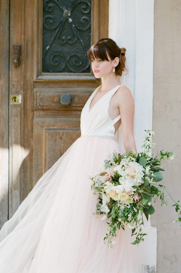 Bride in an elegant two-tone gown holding a bouquet