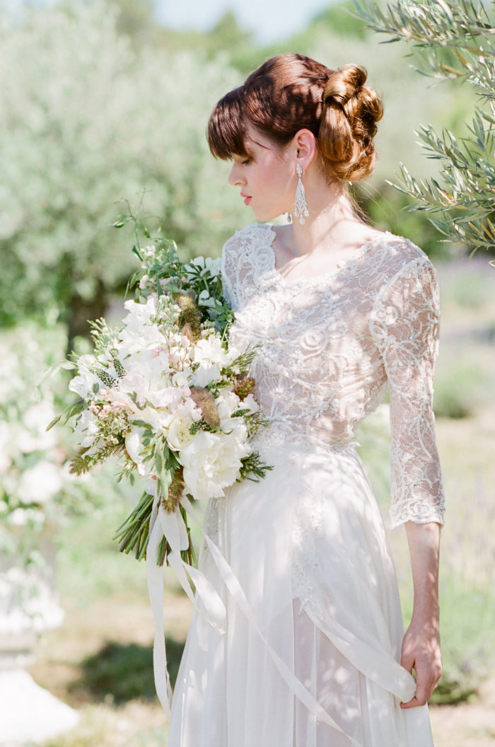 Bride with a beautiful updo holding a bouquet at La Coquillade