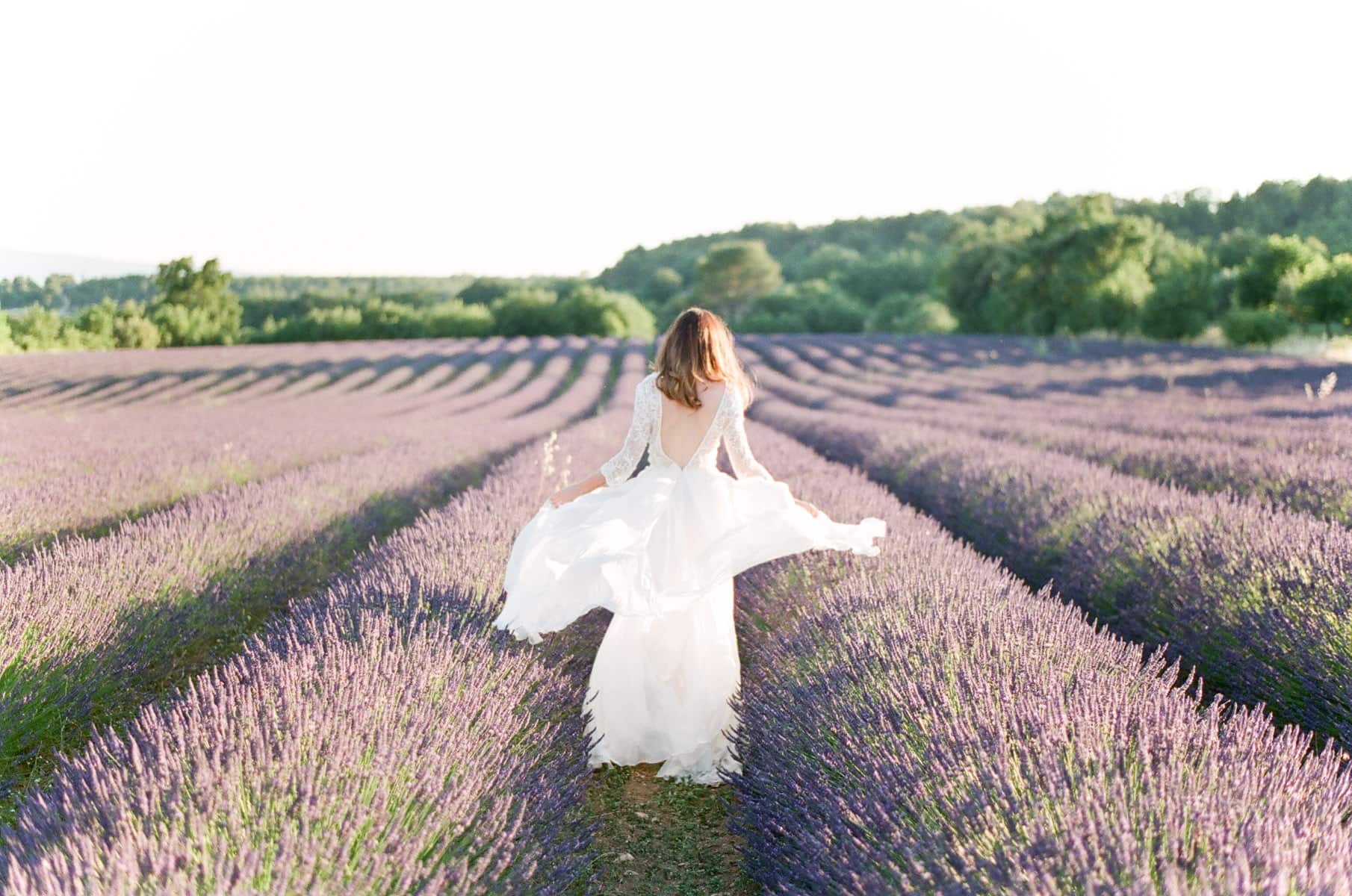 Wedding portrait of a bride running through a lavender field in Provence France