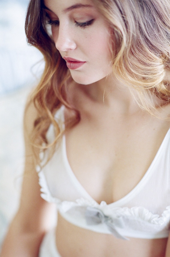 Bride wearing white bralette during elegant Colorado boudoir portrait session