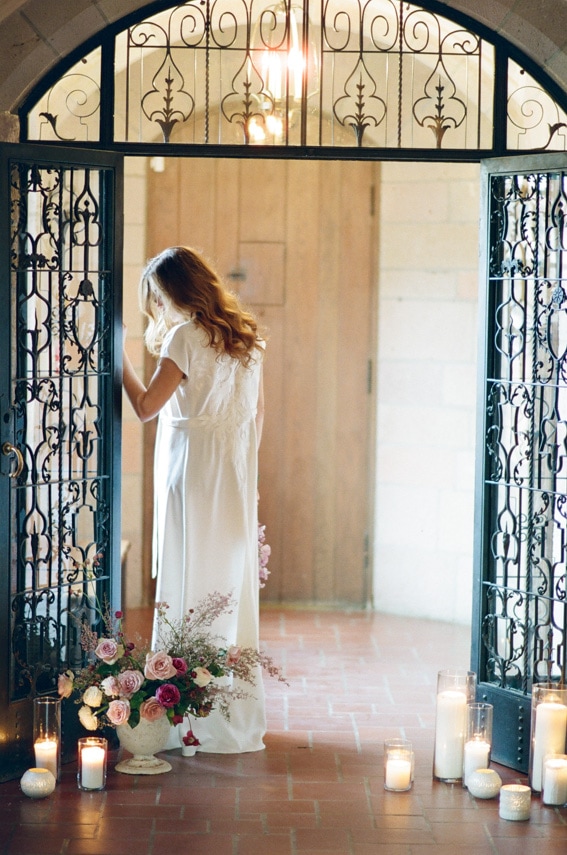 Bride wearing high-waisted black shorts and an elegant see-through white robe during boudoir portrait session in Colorado