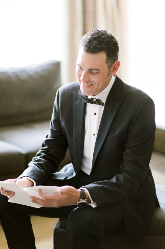 Groom reading a letter on his wedding day at The Riverfront Westin Resort and Spa in Beaver Creek