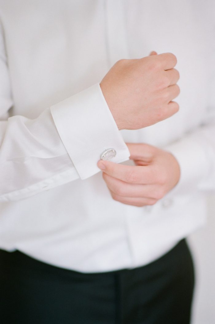 Groom putting on his cufflinks in Boulder Colorado