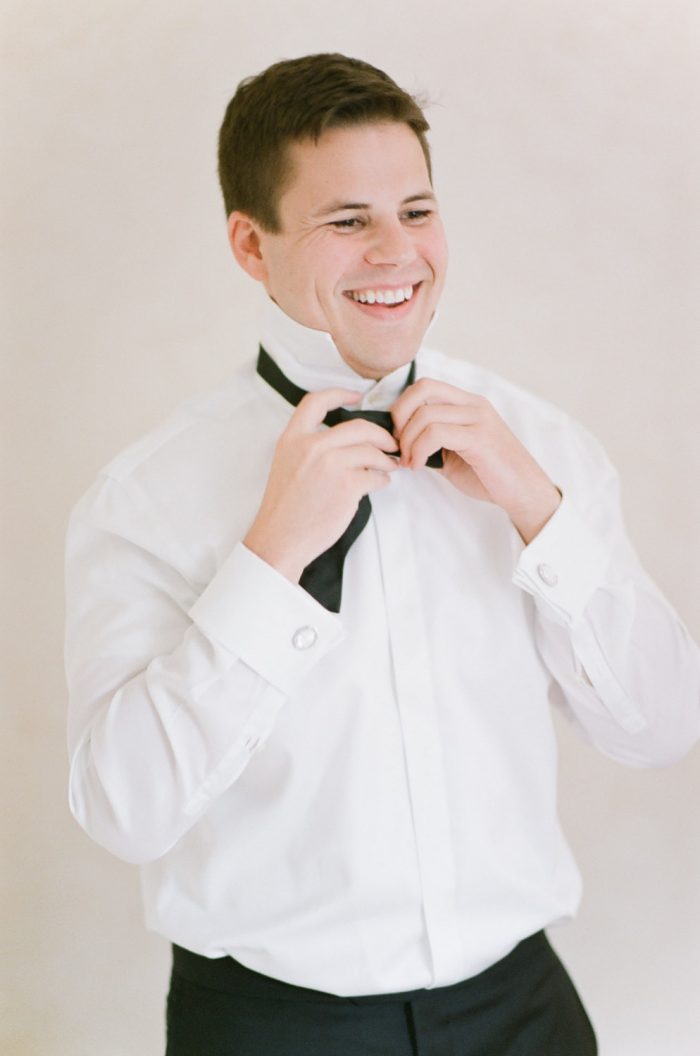 Happy groom tying his bowtie in Boulder Colorado