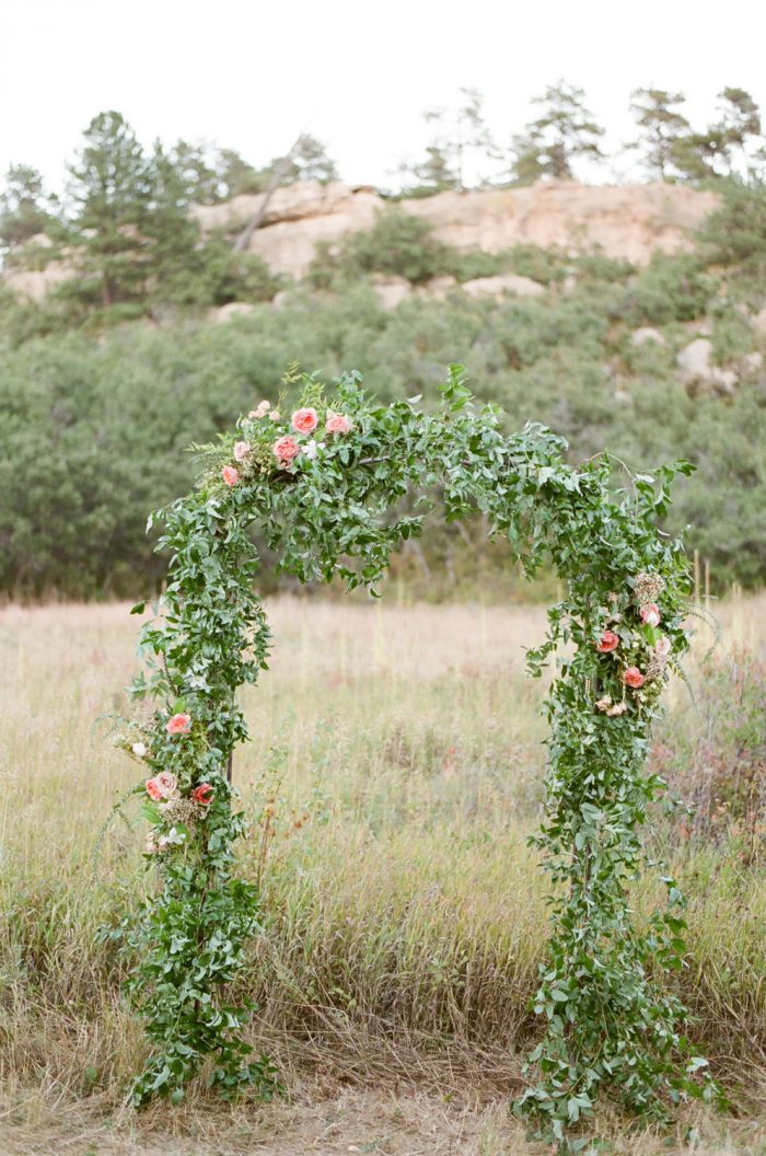 Castle Pines wedding ceremony arch covered in greenery
