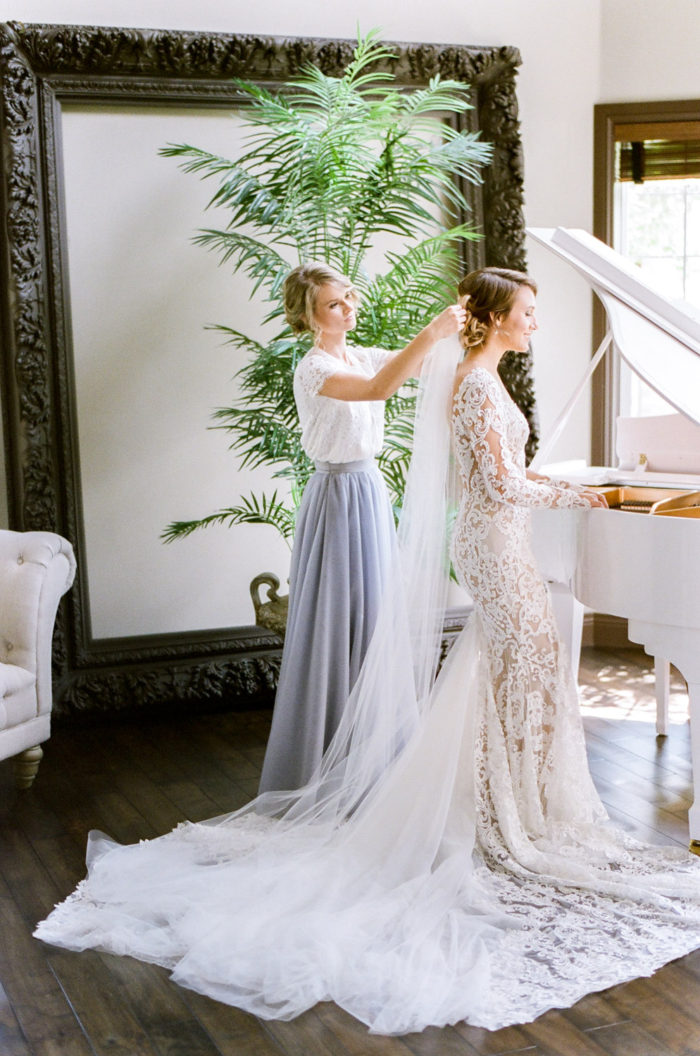 Bride putting her veil on with her bridesmaid at Castle Pines in Colorado