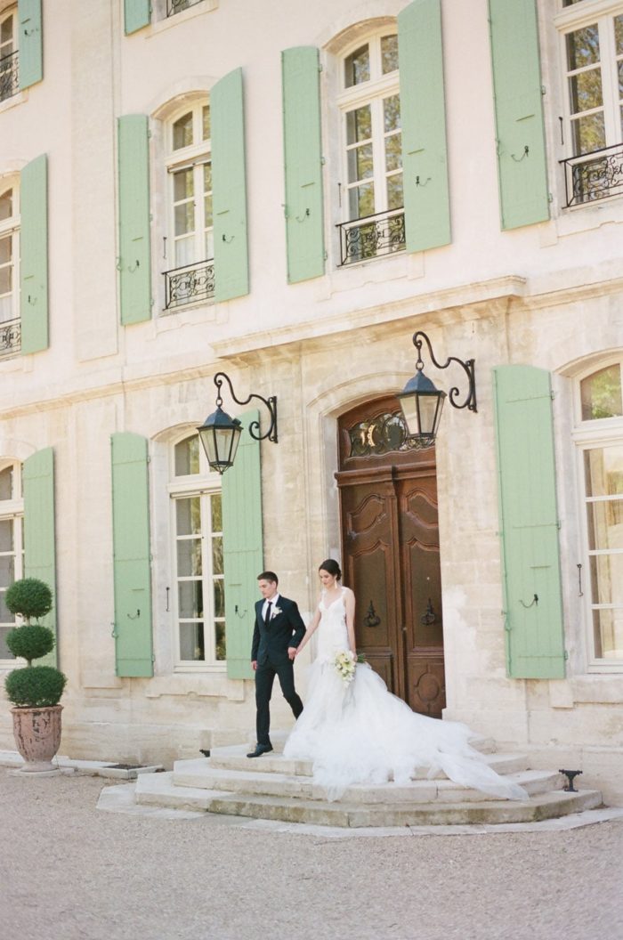 Bride and groom standing outside of Chateau de Tourreau in France