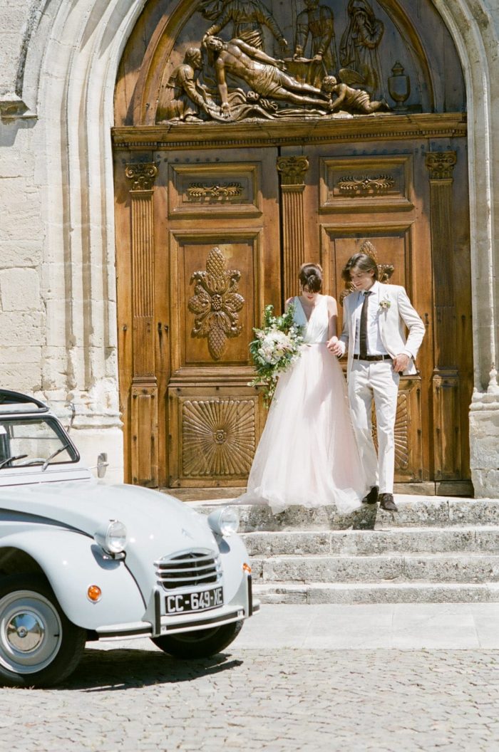 Couple walking down the steps to their getaway car after their wedding ceremony