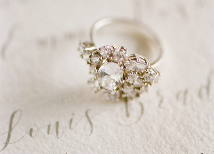 Engagement ring sitting on an invitation suite