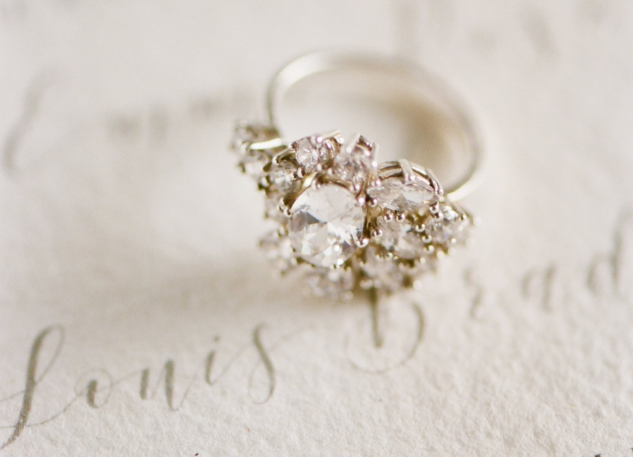 Engagement ring sitting on an invitation suite