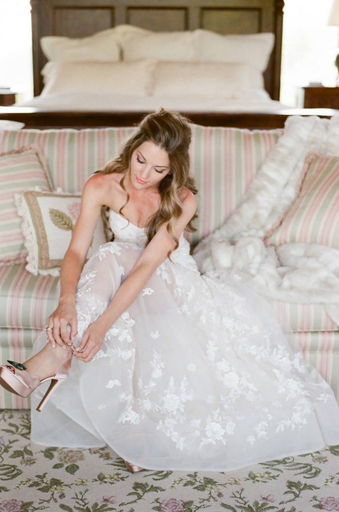 Telluride bride putting on her shoes and wearing a Winnie Couture Dress