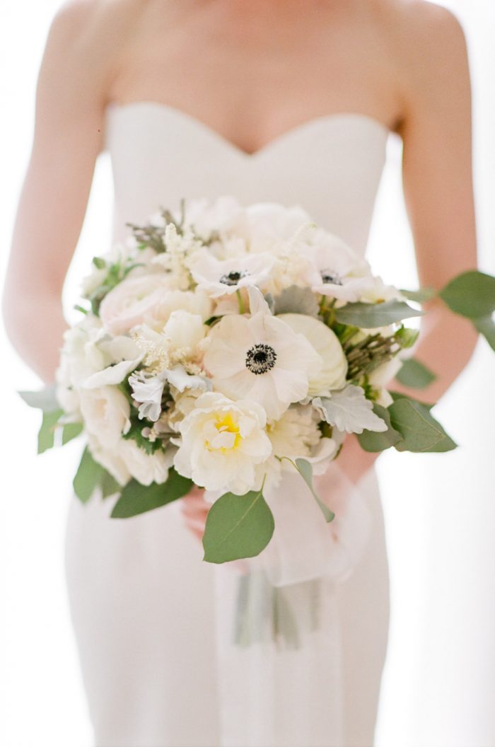 Bride in a strapless dress holding a bouquet at the Halcyon Hotel in Denver