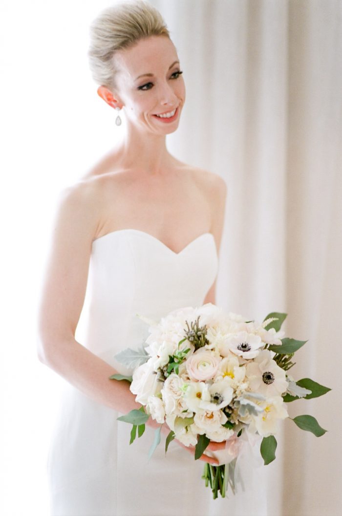 Bride in a strapless dress holding a bouquet at the Halcyon Hotel in Denver