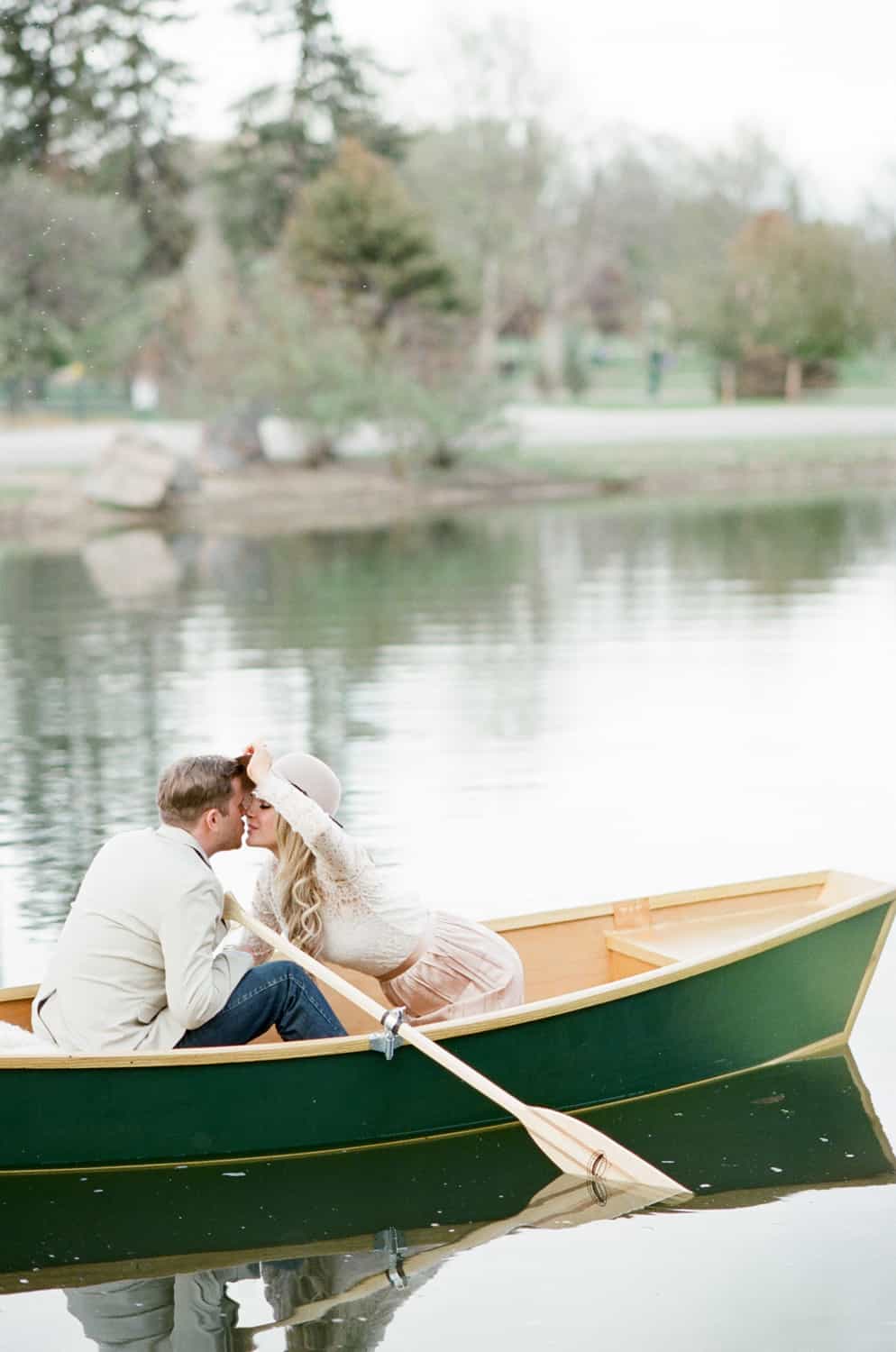Couple sitting in a boat during their Wash Park Denver engagement session