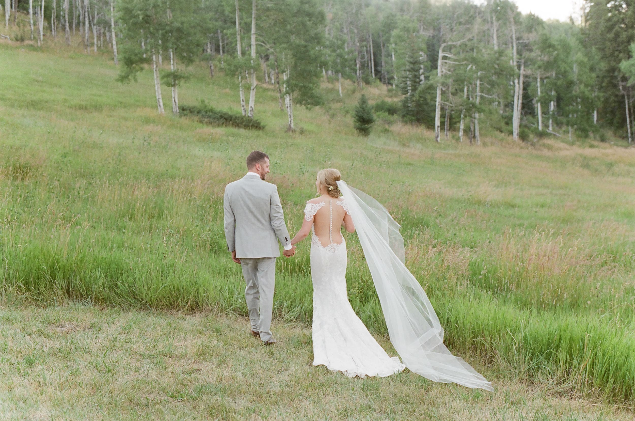 Bride and groom walking hand in hand at Eaton Ranch in Colorado