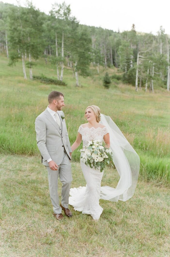 Bride and groom hold hands at their Vail wedding at Eaton Ranch