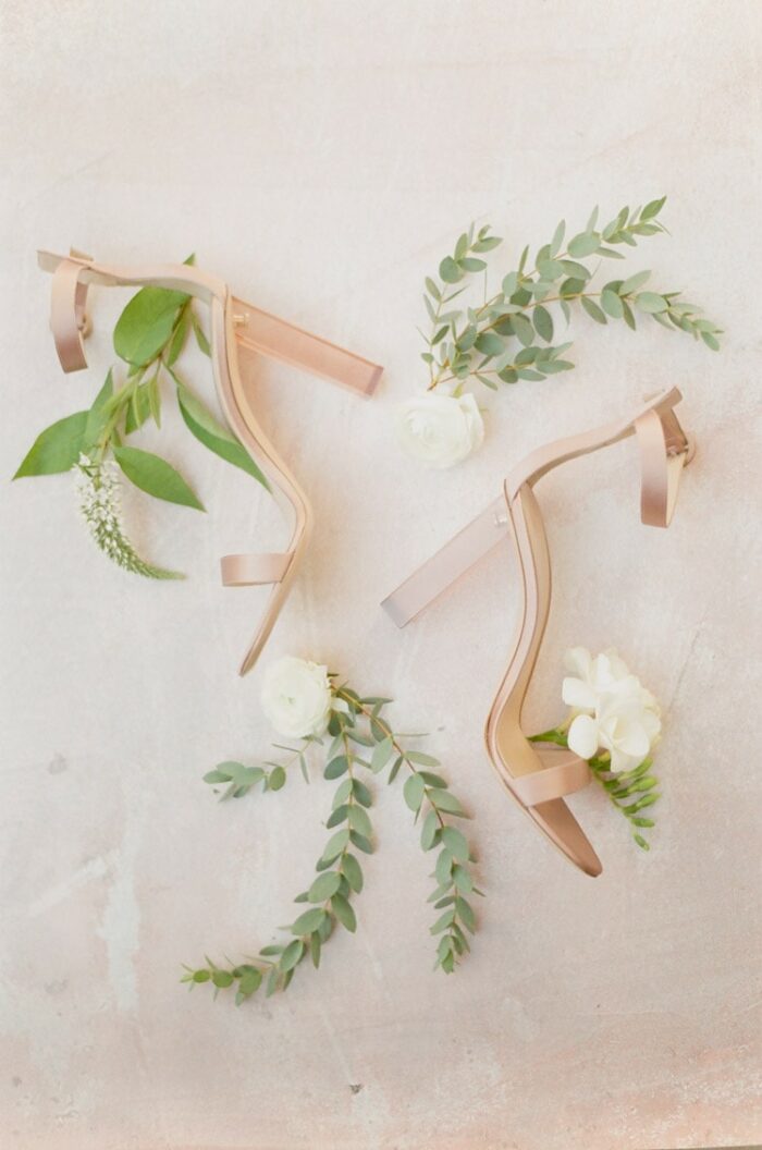 High heels with an ankle strap surrounded by greenery