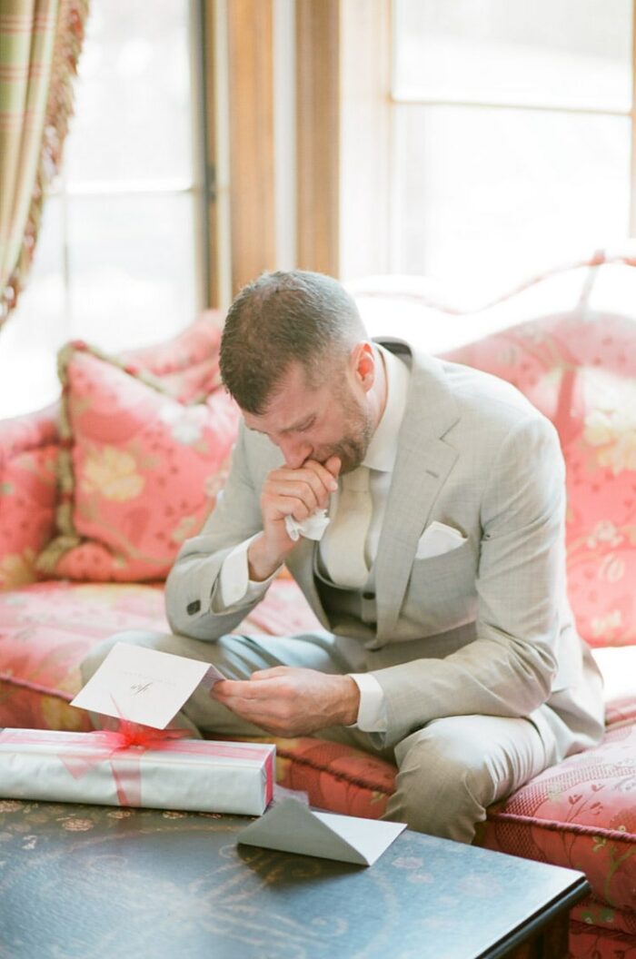 Groom reads a letter from his bride on his wedding day at Eaton Ranch in Vail
