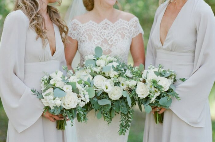 Bride and bridesmaids holding white bouquets at Eaton Ranch wedding in Vail