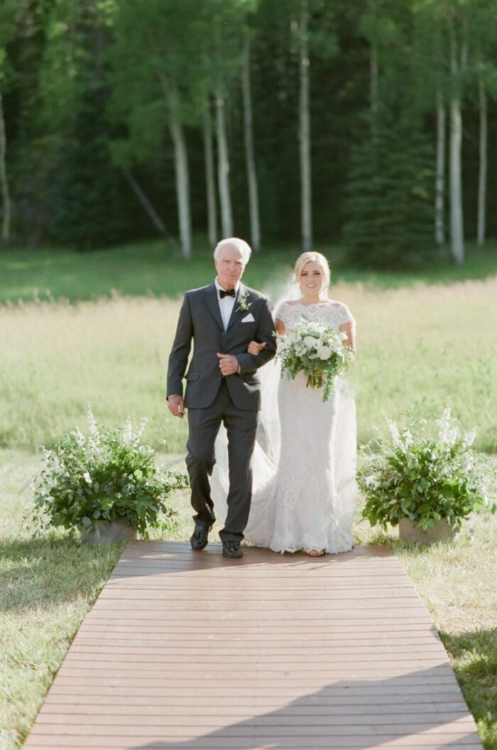 Bride walks down the aisle at an outdoor wedding in Vail Colorado