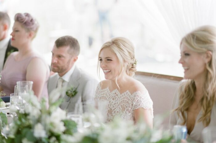 Bride and groom smile as toasts are given during their reception at Eaton Ranch in Vail
