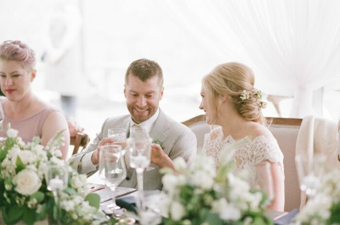 Bride and groom smile as toasts are given during their reception at Eaton Ranch in Vail