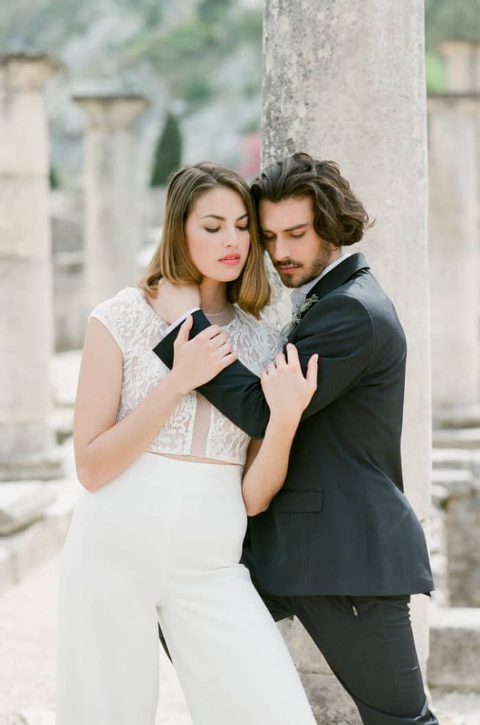 Bride and groom embracing each other in front of the ancient ruins of Glanum