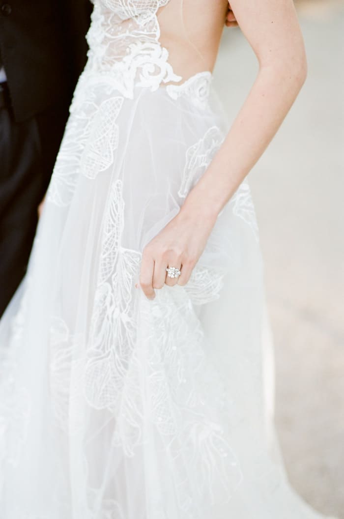 White wedding gown with woman wearing ring on finger