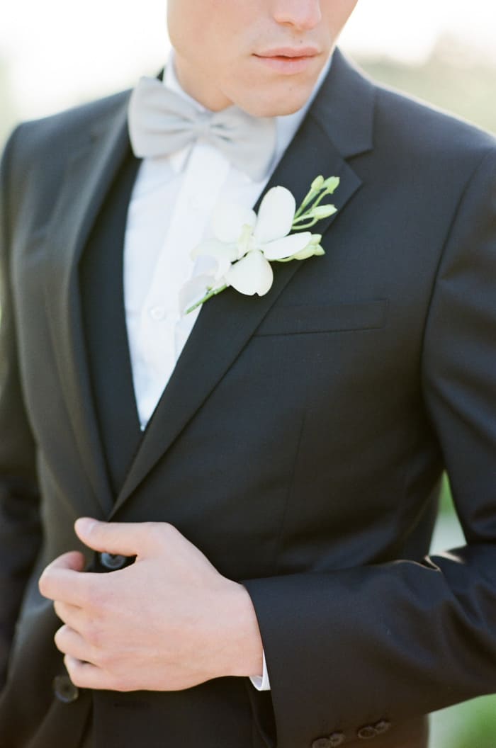 Groom in black suit wearing Boutonniere
