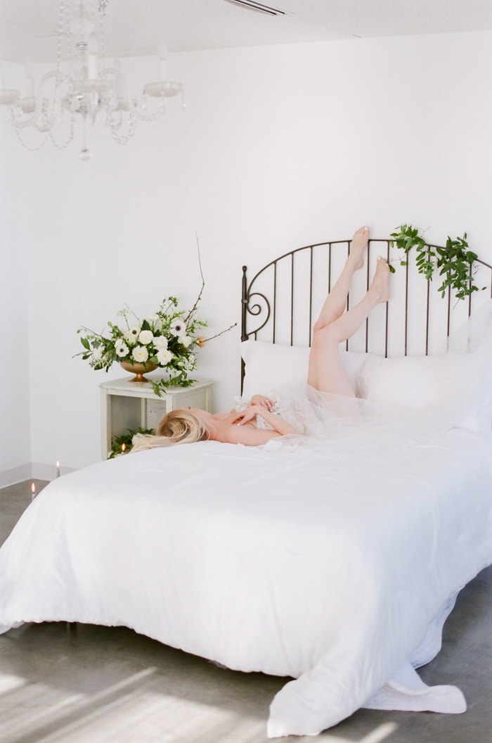 Bride lying on top of a bed for her boudoir session