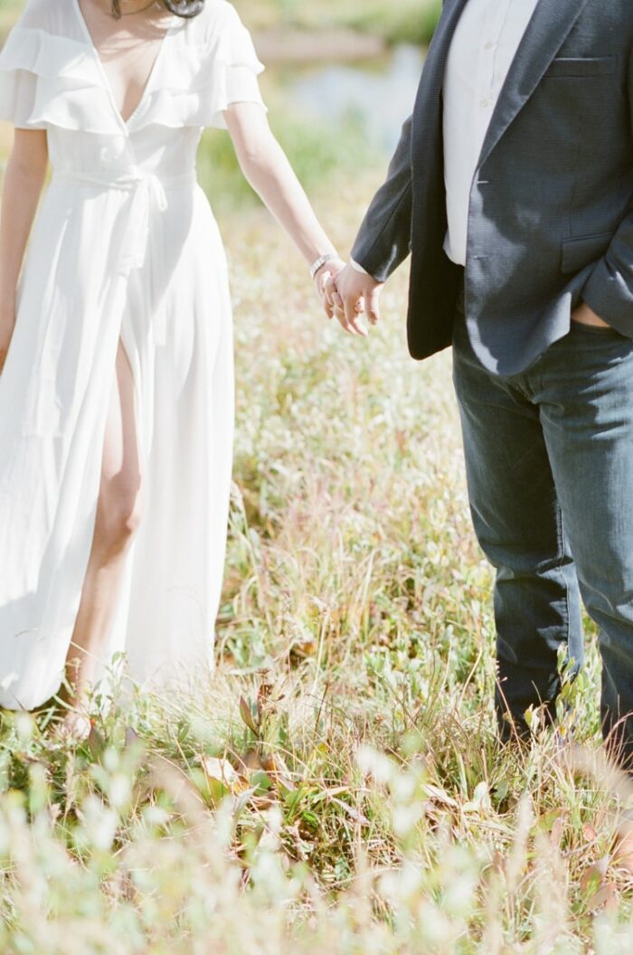 Engaged couple holding hands wearing formal outfits