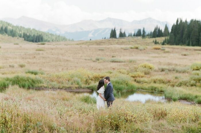 Couple kissing with scenic backdrop of Vail Valley, Colorado during the Fall season