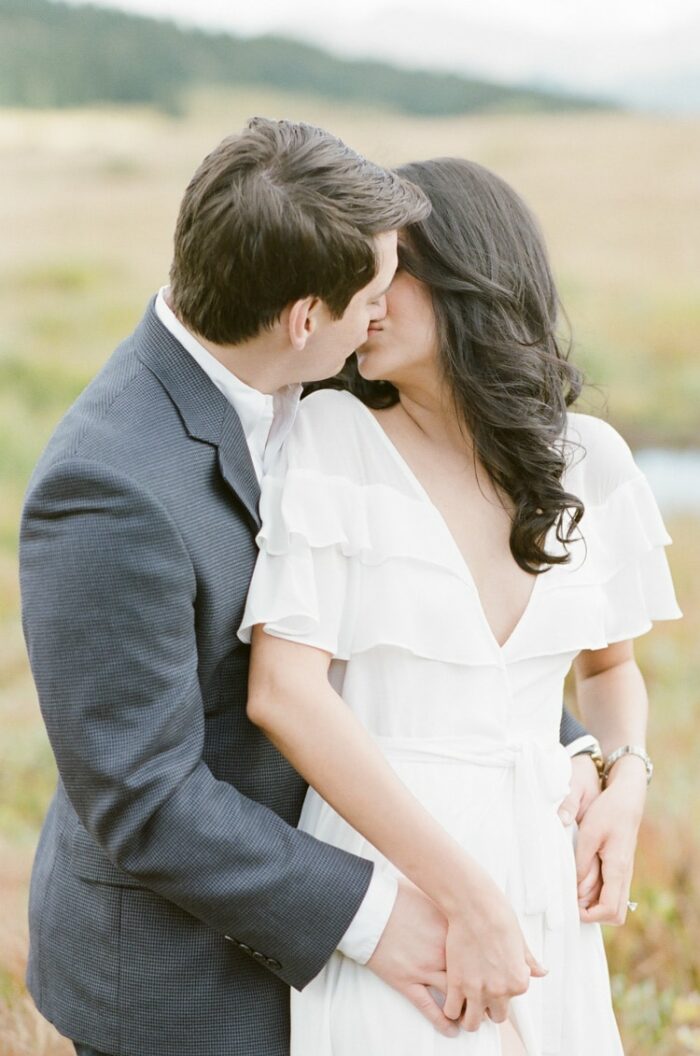 Man embracing woman from behind while kissing