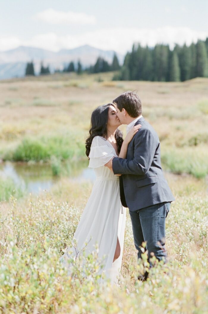 Engagement portrait session of couple kissing in Colorado