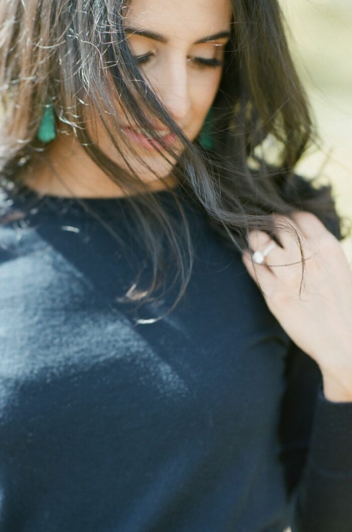 Close up portrait of woman wearing navy sweater and turquoise earrings