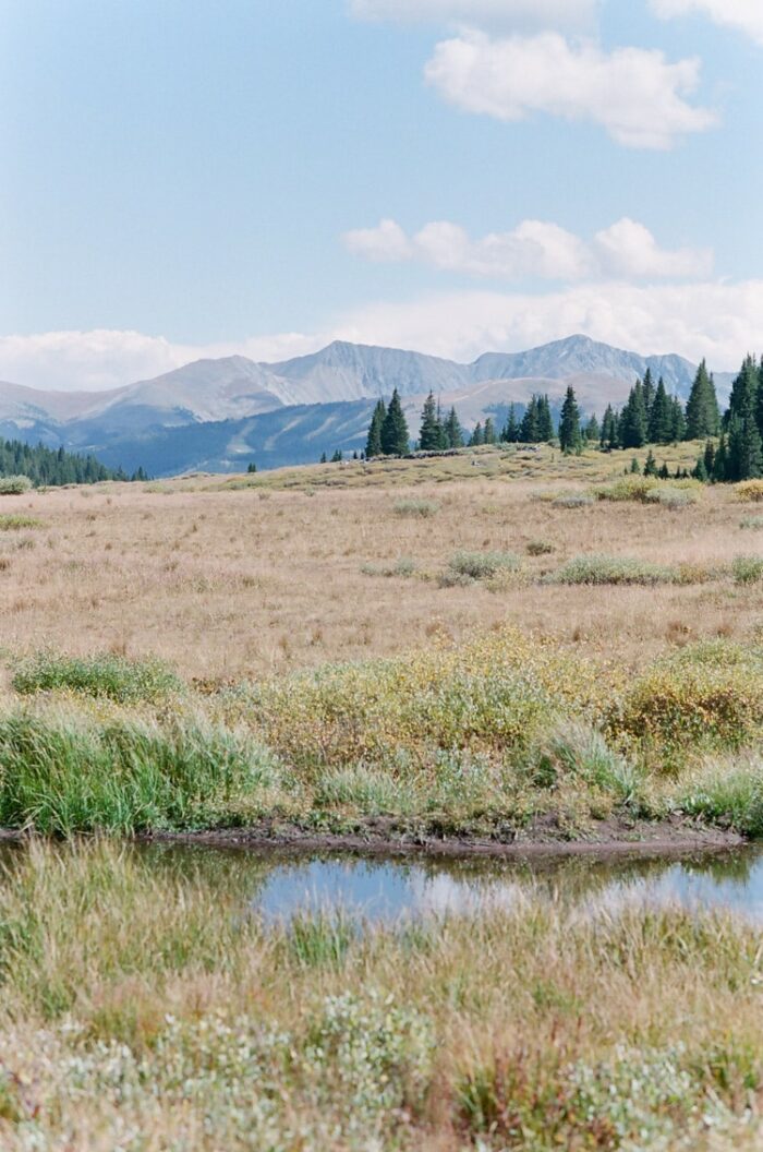 Scenic Vail Valley with view of body of water, vegetation, and mountains in the distance