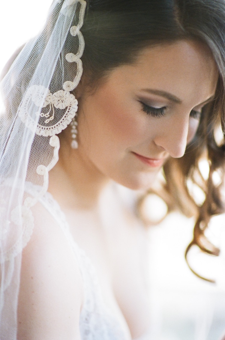 Bride wearing veil and white lingerie during an elegant boudoir portrait session