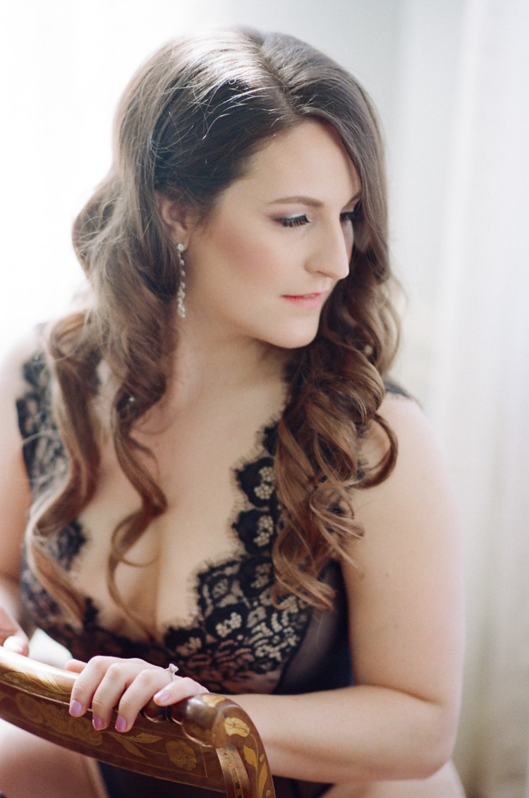 Bride wearing black lacy lingerie during elegant boudoir session