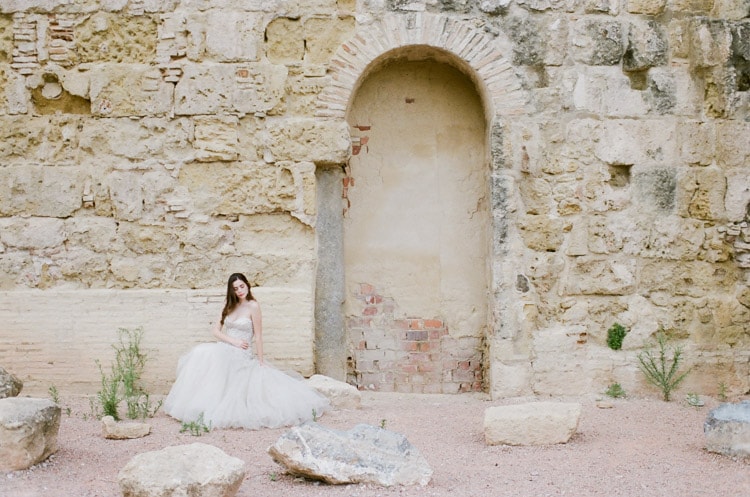 Bride in front of old stone building in Cordoba Spain