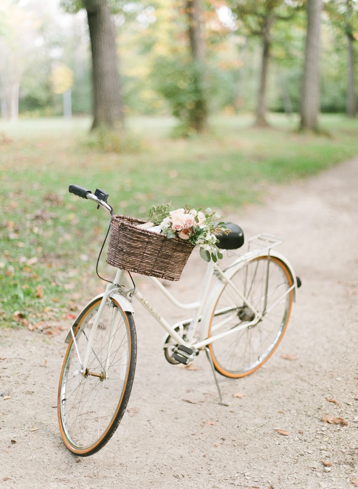 White bicycle with bouquet of flowers in basket