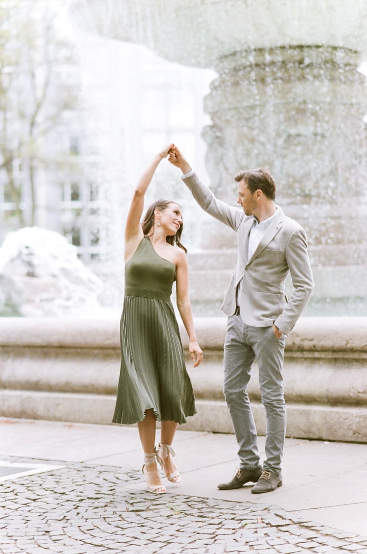 Couple dancing in front of a fountain in Munich
